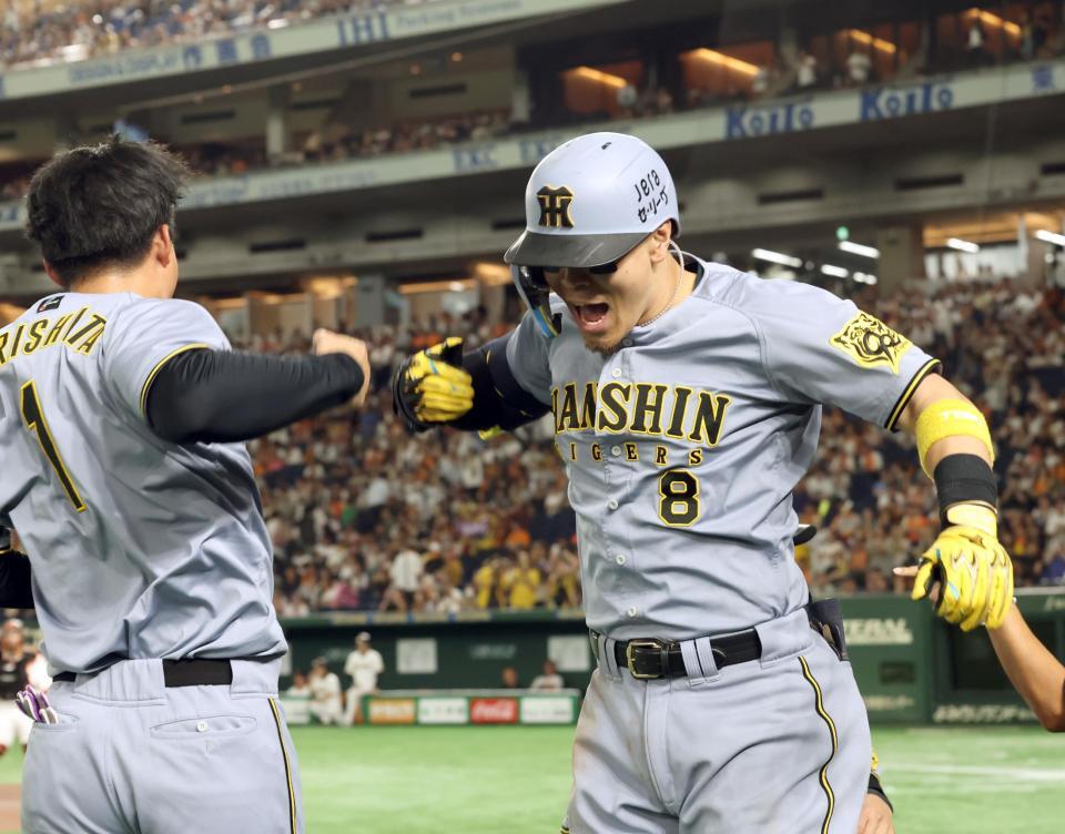 　１１回、２ランを放った佐藤輝は森下と歓喜する（撮影・田中太一）