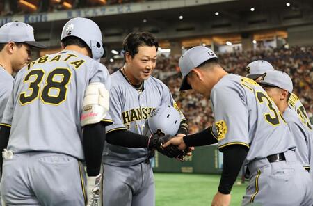 　３回、小幡（左）の２ランで生還した大山は糸原に迎えられ握手をする（撮影・田中太一）