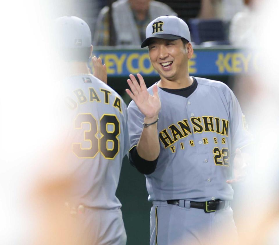 　巨人に連勝し、小幡（左）と笑顔でタッチする藤川監督（撮影・西岡正）