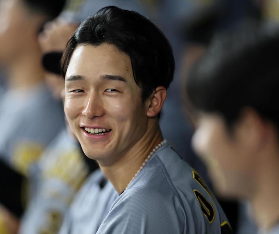 　３回、２打席連続で本塁打撃練習をするを放った小幡はベンチで笑顔を見せる（撮影・田中太一）