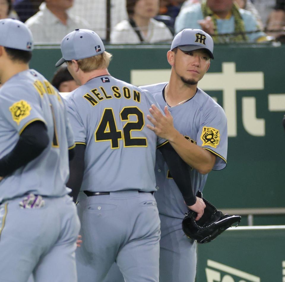 　７回、同点３ランを許したネルソン（左）をねぎらう伊藤将（撮影・西岡正）