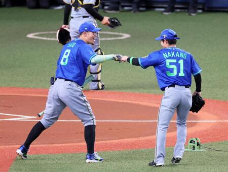 　ホームランダービーで打撃投手を務めた中野（右）とタッチを交わす佐藤輝（撮影・立川洋一郎）