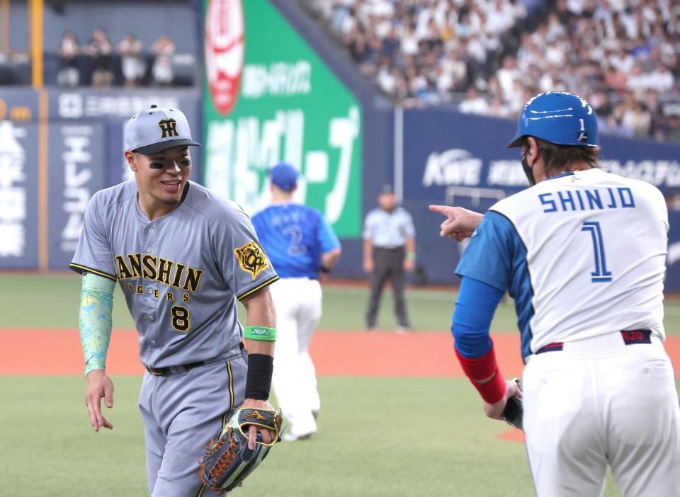 　３回、三塁コーチャーに就く新庄監督に声をかけられる佐藤輝（左）＝撮影・北村雅宏