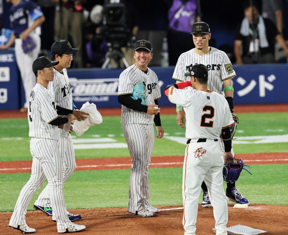 　２回、ピンチを迎えた村上（中央）は、ベンチからマウンドへ駆けよる（左から）近本、大山に笑顔を見せる（撮影・田中太一）