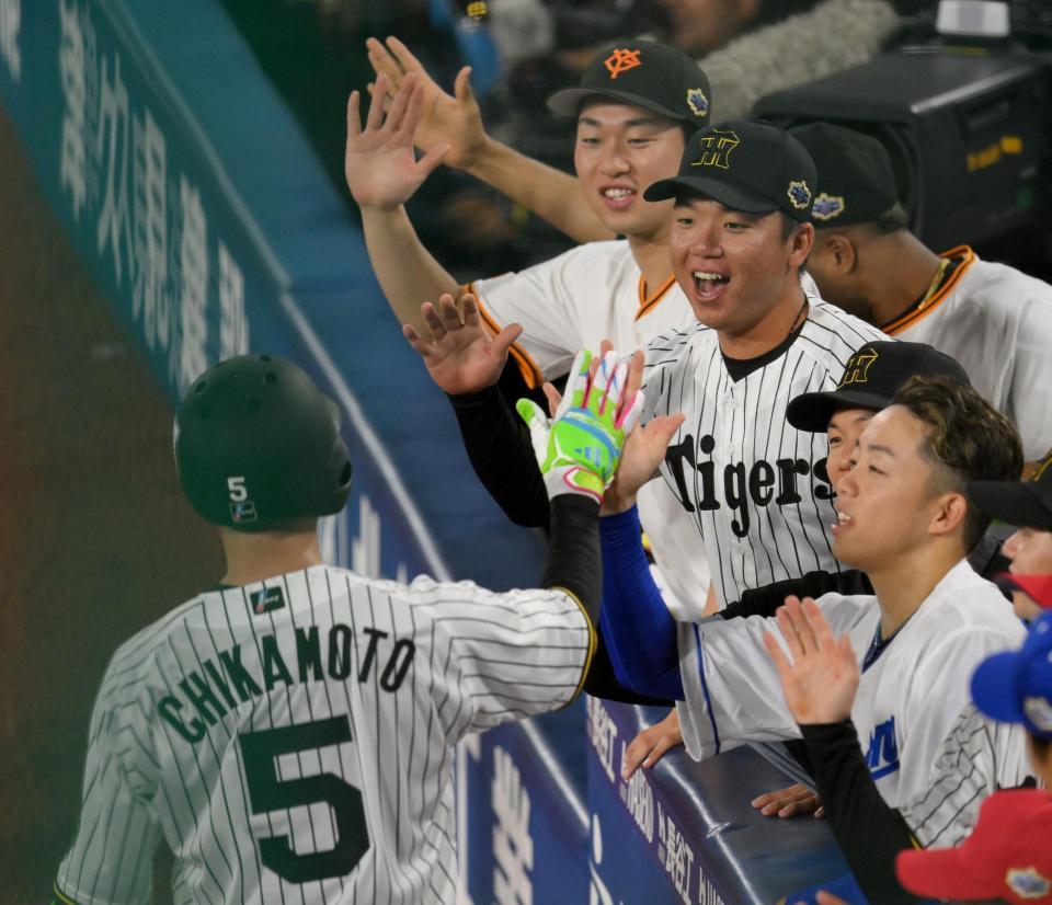 　８回、右越えソロを放った近本（手前）を迎える村上ら（撮影・伊藤笙子）