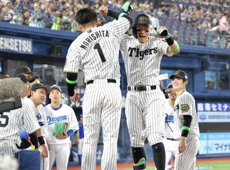 　森下（左）とタッチを交わす佐藤輝（撮影・西岡正）