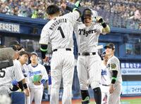 　森下（左）とタッチを交わす佐藤輝（撮影・西岡正）