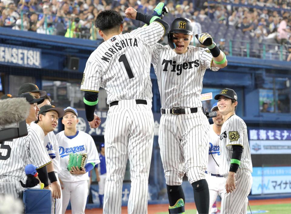 　森下（左）とタッチを交わす佐藤輝（撮影・西岡正）