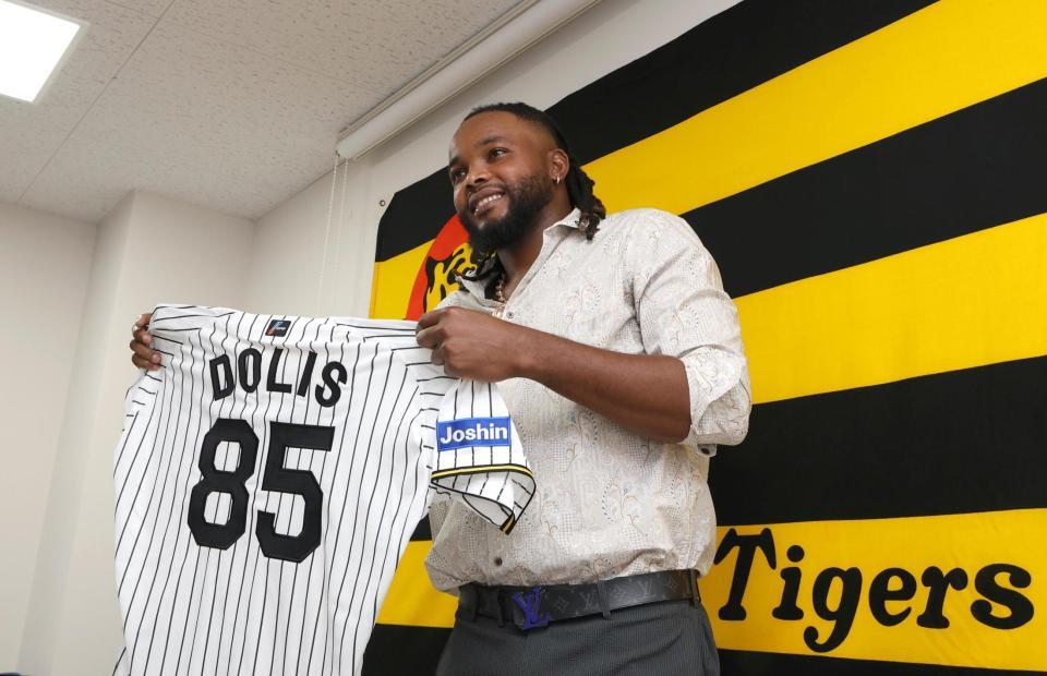 　入団会見を終えてユニホームを披露するドリス（撮影・北村雅宏）