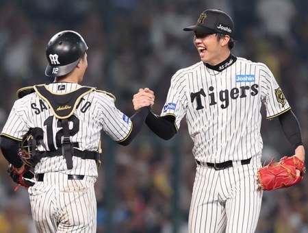 　９回、宮崎を二ゴロに打ち取って完封勝利を飾り、坂本（左）と喜びを分かち合う才木（撮影・立川洋一郎）