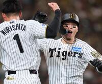 　６回、ソロを放って生還し森下（左）とタッチを交わす佐藤輝（撮影・立川洋一郎）