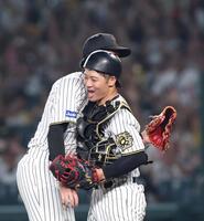 　完封勝利を挙げた才木と抱き合う坂本（右）＝撮影・北村雅宏