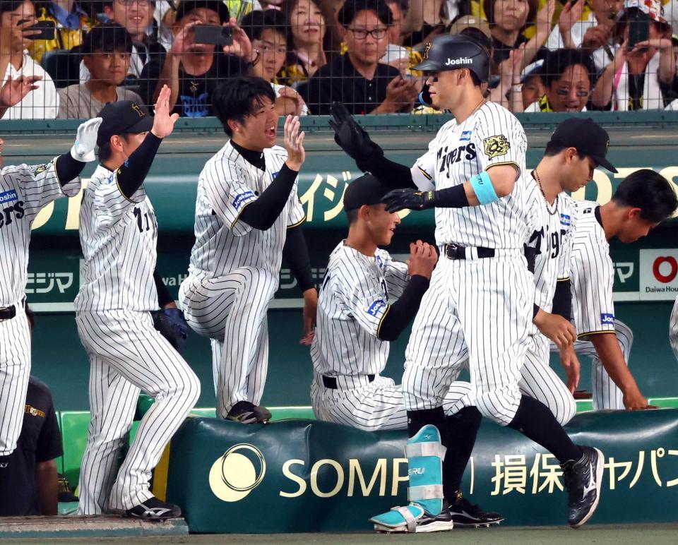 　６回、ソロを放った佐藤輝を迎える才木（中央）ら阪神ナイン（撮影・山口登）