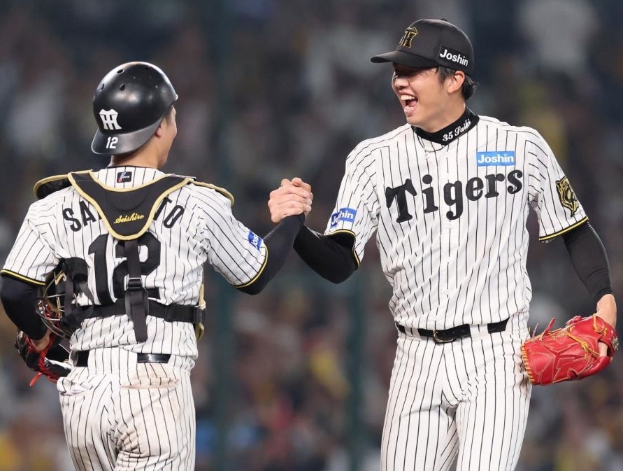 　９回、宮崎を二ゴロに打ち取って完封勝利を飾り、坂本（左）と喜びを分かち合う才木（撮影・立川洋一郎）