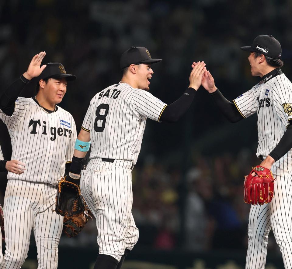 　完封勝利を挙げた才木とタッチを交わす佐藤輝（中央）と大山（左）＝撮影・北村雅宏