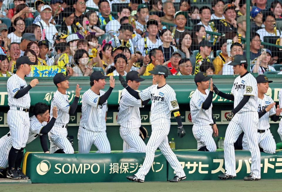 　２回、森下の三ゴロとエラーで生還しナインとタッチを交わす（手前右から）高橋と近本（撮影・立川洋一郎）