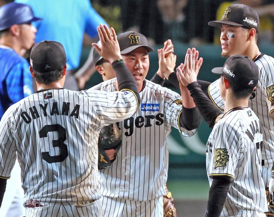 　９回を締めくくりナインと勝利のタッチを交わす桐敷（中央）＝撮影・立川洋一郎