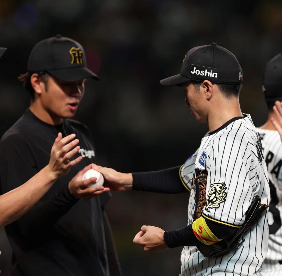 　高橋にウイニングボールを手渡す近本（右）＝撮影・北村雅宏