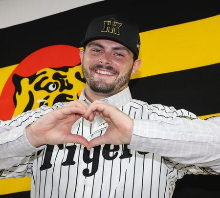 　笑顔でハートマークをつくるハートウィグ（撮影・田中太一）