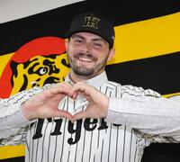 　笑顔でハートマークをつくるハートウィグ（撮影・田中太一）