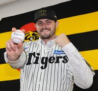 　入団会見でポーズを決めるハートウィグ（撮影・田中太一）