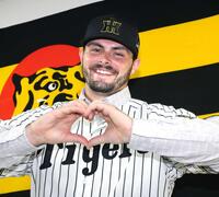 　笑顔でハートマークをつくるハートウィグ（撮影・田中太一）