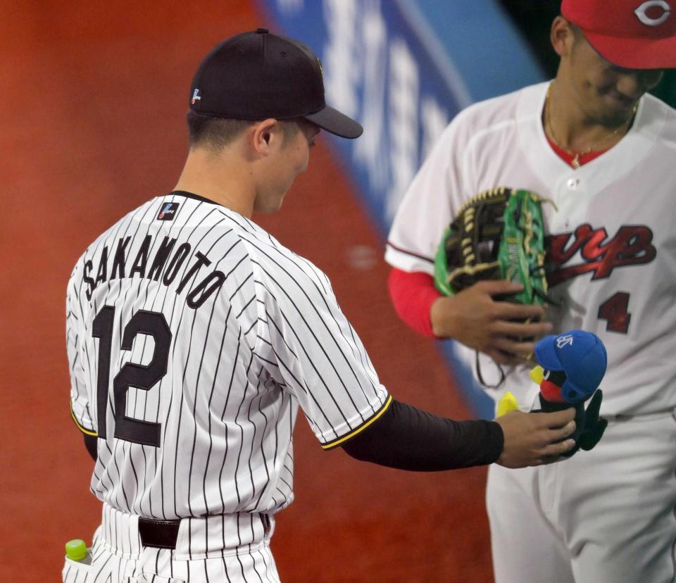 　５回、リリーフカーに残されていたつば九郎をベンチへ持っていく坂本＝２４日、横浜スタジアム