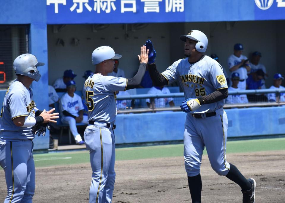 　初回に先制の３ランを放ち、佐野とハイタッチをするヘルナンデス