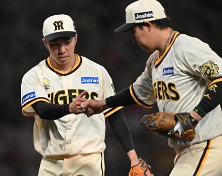 　８回を無失点に抑え、大山（右）とグータッチする石井（撮影・西田忠信）