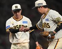 　８回を無失点に抑え、大山（右）とグータッチする石井（撮影・西田忠信）