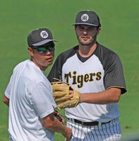 　キャッチボールを終えて金村コーチとタッチを交わすハートウィグ（右）＝撮影・北村雅宏