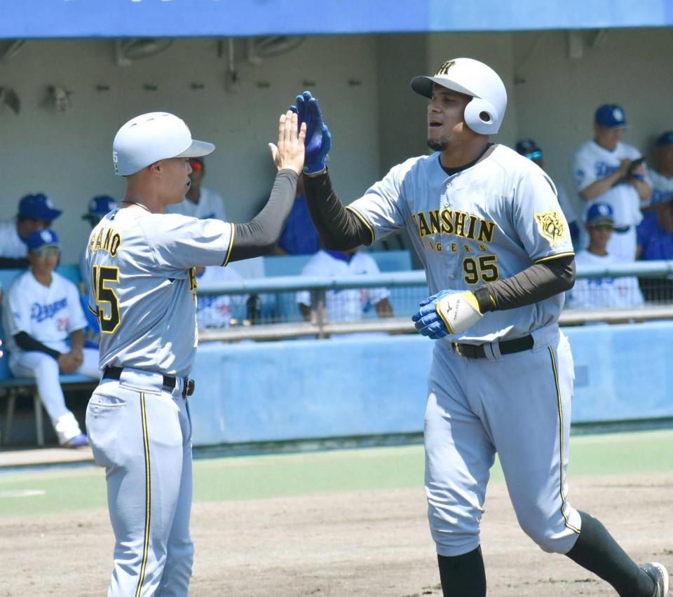　１回、先制３ランを放ち、佐野（左）とタッチを交わすヘルナンデス