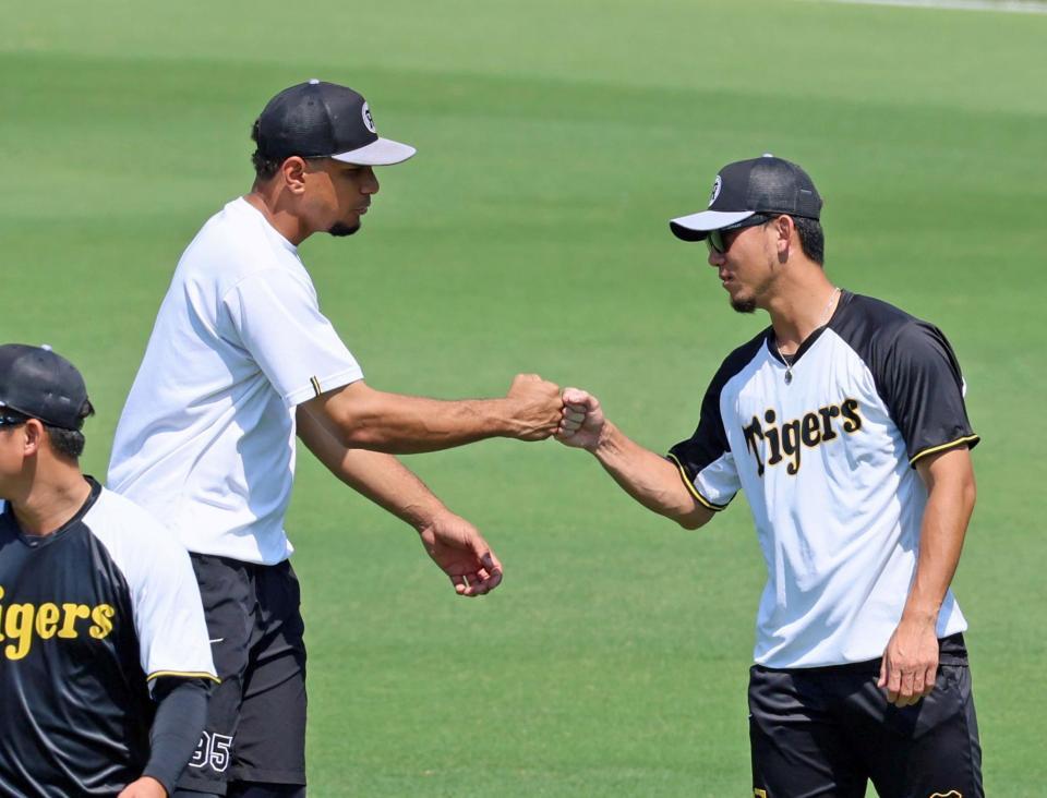 　伊藤将（右）とタッチを交わすヘルナンデス（撮影・立川洋一郎）