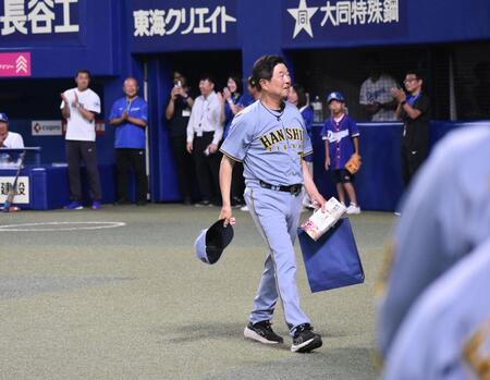 　贈呈品を受け取り、笑顔でベンチへ帰る平田２軍監督