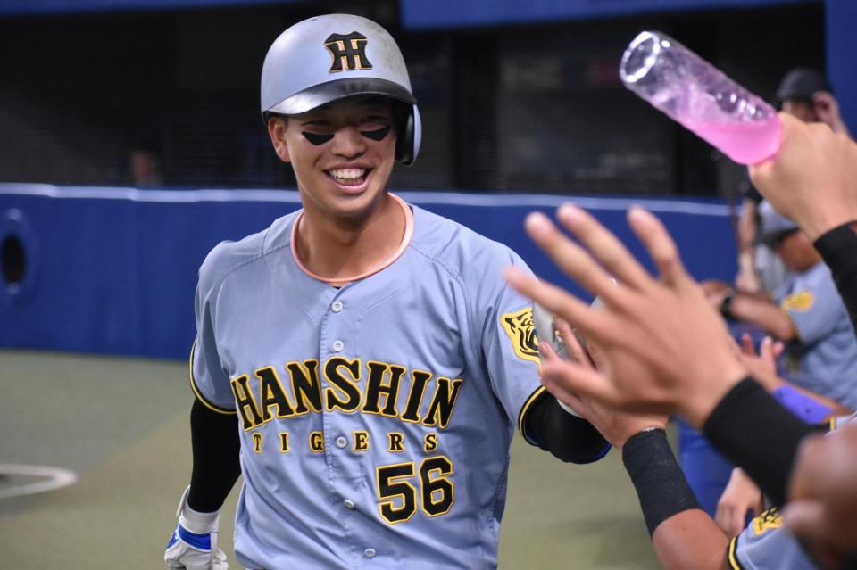 　本塁打を放ち、ナインの祝福を受ける百崎