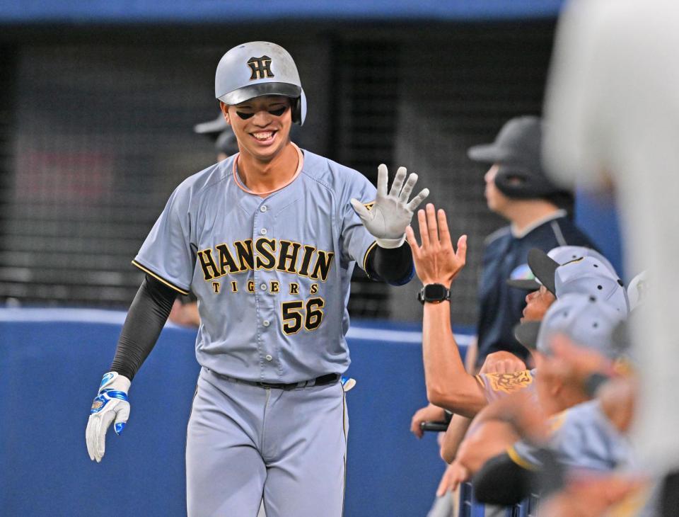 　５回、勝ち越しソロを放ち、ナインに迎えられる百崎