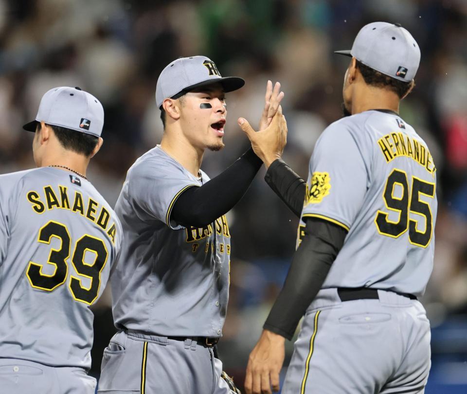 　チームの勝利に貢献し、ナインと喜び合う佐藤輝（撮影・田中太一）