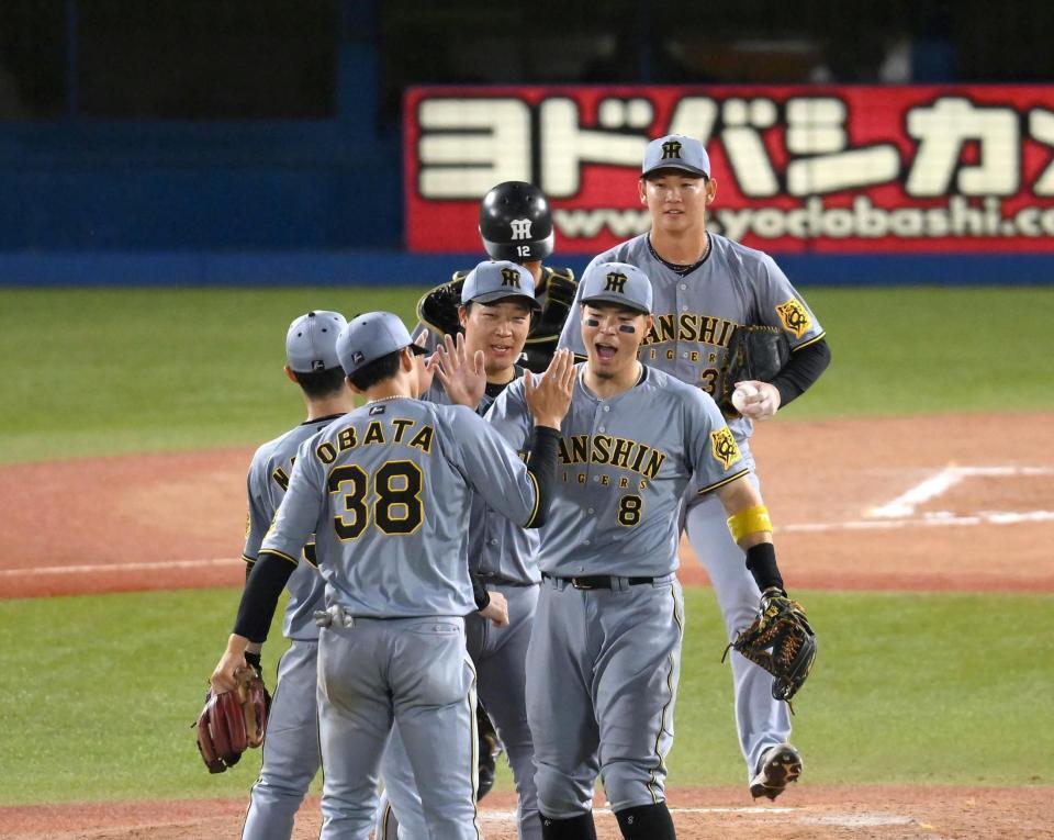 　１０回、勝利を決めてタッチを交わす佐藤輝（中央）ら阪神ナイン（撮影・堀内翔）