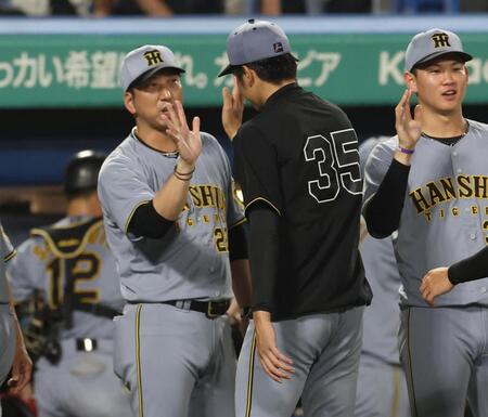 　才木とタッチをする藤川監督（撮影・佐々木彰尚）