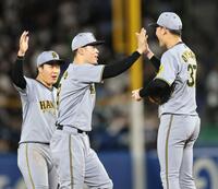 　チームの勝利に貢献し、セーブを挙げた及川とタッチを交わす佐藤輝（撮影・田中太一）