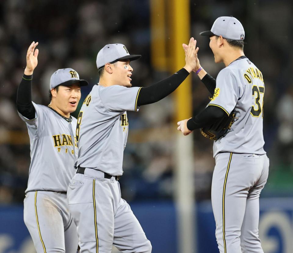 　チームの勝利に貢献し、セーブを挙げた及川とタッチを交わす佐藤輝（撮影・田中太一）