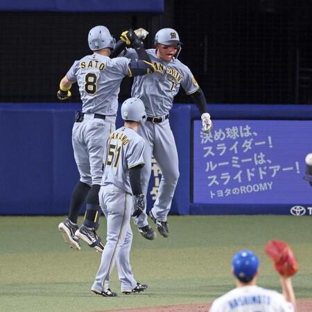 　８回、逆転３ランを放って生還し森下（１）とタッチを交わす佐藤輝（撮影・立川洋一郎）