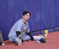 　外野で座り込みストレッチをする藤川監督（撮影・立川洋一郎）