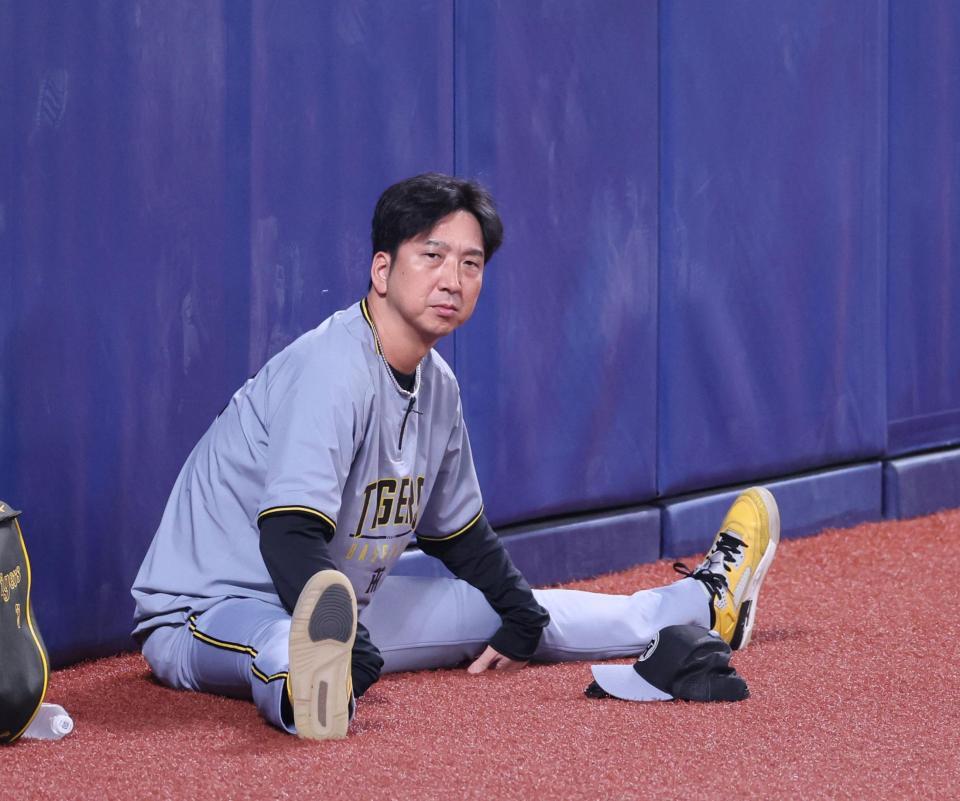 　外野で座り込みストレッチをする藤川監督（撮影・立川洋一郎）