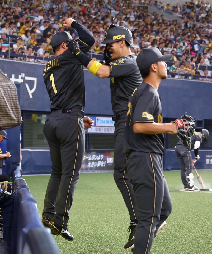 　４回、先制ソロを放った佐藤輝（中央）は森下とタッチする（撮影・山口登）