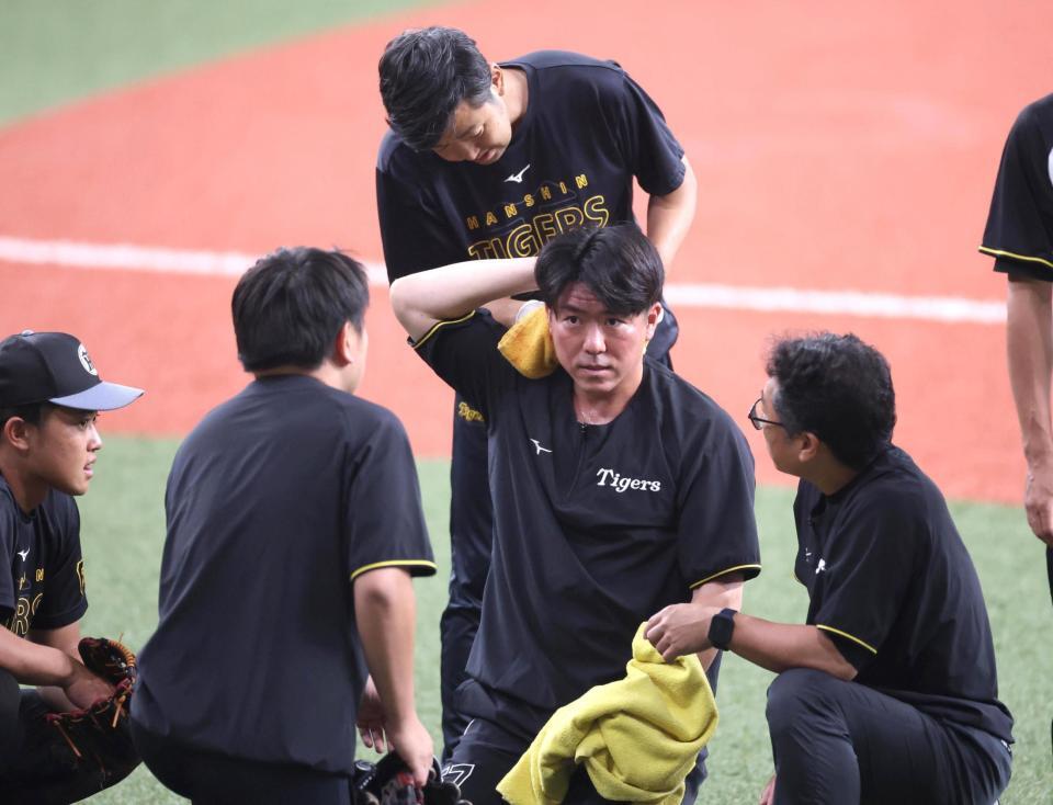 　練習中のボールが長坂（中央）の頭部に当たり、心配するチームスタッフら（撮影・北村雅宏）