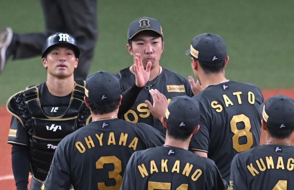 　最後を締め、勝利を喜ぶ石井（中央）ら阪神ナイン（撮影・飯室逸平）