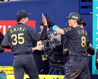 　３回、才木（左）はソロを放ち生還した佐藤輝とタッチする（撮影・山口登）