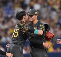 　完投勝利した才木（左）と抱き合う佐藤輝（撮影・西田忠信）