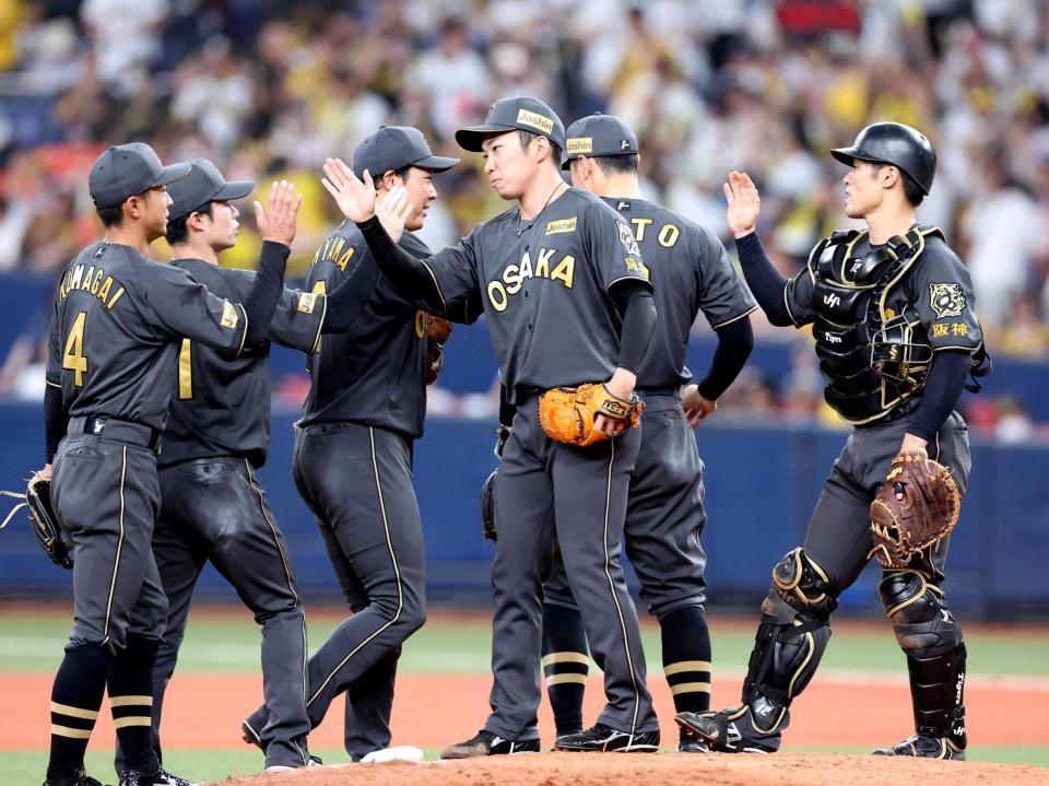 　最後を締めた石井（中央）はナインとタッチを交わす（撮影・北村雅宏）